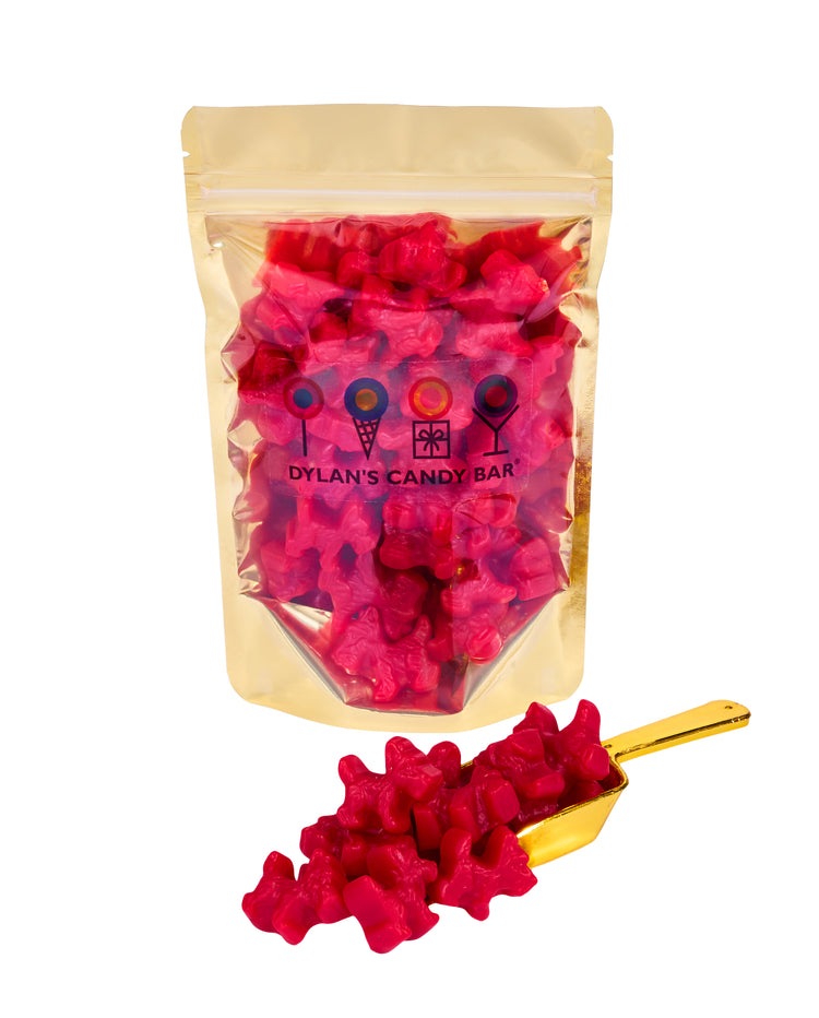 Cherry Licorice Scottie Dogs in resealable gold mylar bag next to Cherry Licorice Scottie Dogs overflowing from gold scoop