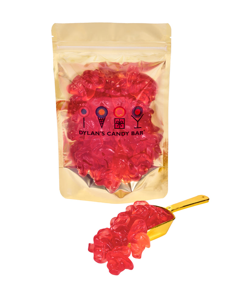 Strawberry Gummy Flamingos in resealable gold mylar bag next to Strawberry Gummy Flamingos overflowing from gold scoop